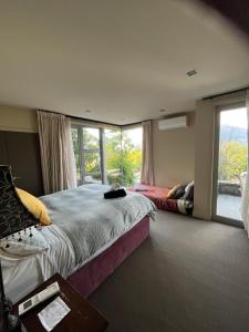a bedroom with a bed and a large window at Rangatira at 13 Poole lane in Queenstown