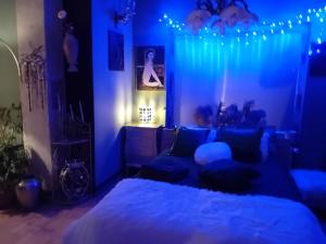 リュブリャナにあるROSE Room of 40m2 with terrace 25m2の青い照明付きのベッドルーム1室、ベッド1台が備わるベッドルーム1室が備わります。