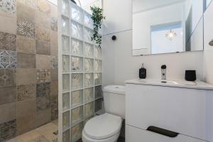 uma casa de banho com um WC, um lavatório e um espelho. em San Miguel Terraza Tranquilo Moderno em Jerez de la Frontera