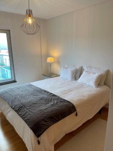 una camera da letto con un grande letto bianco e una finestra di Penthouse Terrace Apartment a Ponta Delgada