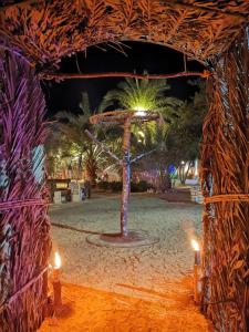 a wooden cross in the middle of a beach at night at Desert Escape siwa -with palm & olive Garden - Hot Spring in Siwa