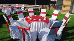 een rode en witte tafel en stoelen met een rode en witte gestreepte tafel en stoelen bij WE hotels Islamabad in Islamabad