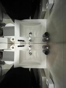 a white sink in a bathroom with two toilets at Katerina Holiday House in Anavissos