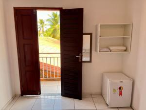 an open door in a room with a refrigerator at Pousada Recanto dos Parente - Icaraizinho de Amontada in Amontada