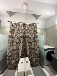 uma casa de banho com um chuveiro e uma parede de pedra em Katerina Holiday House em Anavissos