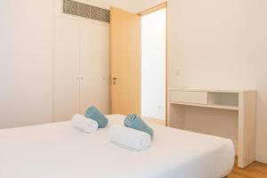 ein Schlafzimmer mit einem weißen Bett mit blauen Kissen darauf in der Unterkunft Forno da Cal Sea House in São Roque