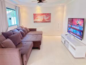 a living room with a couch and a flat screen tv at Chácara dos Lopes in Brotas