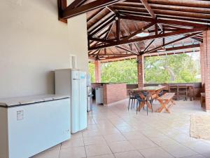 a kitchen with a refrigerator and a table with chairs at Chácara dos Lopes in Brotas