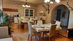 ein Esszimmer mit Tischen und Stühlen sowie eine Küche in der Unterkunft HARTMANN PANZIÓ in Barcs