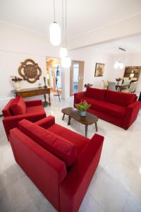 a living room with red couches and a table at AKAKIA VILLA NAFPLIO in Nafplio