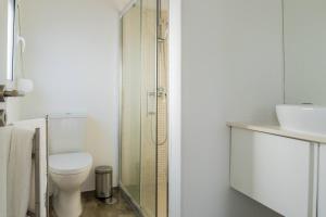 a bathroom with a toilet and a glass shower at Casa dos Mosteiros 1740/AL in Mosteiros