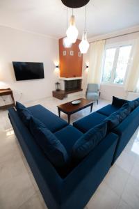 ein Wohnzimmer mit einem blauen Sofa und einem Tisch in der Unterkunft AKAKIA VILLA NAFPLIO in Nafplio
