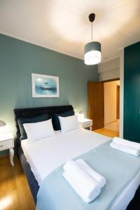 1 dormitorio con 1 cama blanca grande y 2 almohadas en AKAKIA VILLA NAFPLIO, en Nauplia