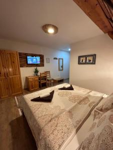a bedroom with a large bed with a tv on the wall at Rustic Lodge Plitvice 1 in Plitvička Jezera