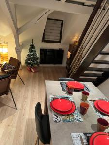un salon doté d'une table avec des plaques rouges et un arbre de Noël dans l'établissement Charmant duplex privatisé, climatisé, 2 chambres, à Strasbourg 19 autres photos