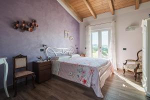 1 dormitorio con 1 cama y 1 silla en Agriturismo Podere Ristella - Wine&Food, en Montemassi