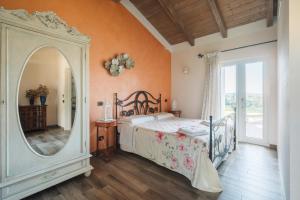 1 dormitorio con cama y espejo grande en Agriturismo Podere Ristella - Wine&Food en Montemassi