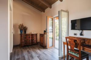 ein Wohnzimmer mit einem TV und Holzböden in der Unterkunft Agriturismo Podere Ristella - Wine&Food in Montemassi