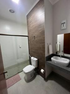 y baño con aseo, lavabo y ducha. en Pousada Ribeirinha en São José da Barra