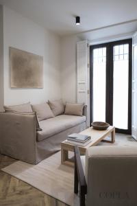 ein Wohnzimmer mit einem Sofa und einem Tisch in der Unterkunft Luxury, Art and Deco apt para 4pax cerca de Plaza de España in Sevilla