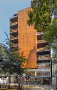 a tall building with trees in front of it at Amberes 64 in Mexico City