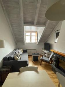 ein Wohnzimmer mit einem Sofa und einem Kamin in der Unterkunft Apartamento Pinos Blancos in Benasque