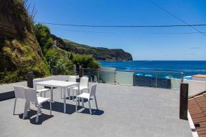 un patio con tavolo e sedie e l'oceano di Mosteiros Beach House a Mosteiros