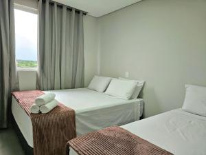 a hotel room with two beds and a window at Apt Novíssimo 3quartos 2vagas garagem prox centro in Foz do Iguaçu