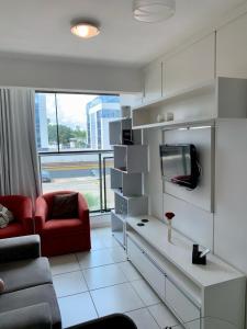 a living room with a couch and a red chair at Kit completa - Parque Norte in Brasília