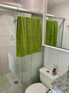 a bathroom with a toilet and a green towel at Kit completa - Parque Norte in Brasilia