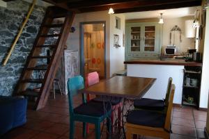 a kitchen with a wooden table and chairs at Chalet Tropical in Arco da Calheta