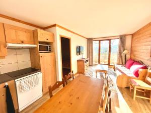 Appartement 3 pièces avec piscine et parking au centre du village - FR-1-505-198 في نوتر دام دو بيلكومبيه: مطبخ وغرفة معيشة مع أريكة وطاولة