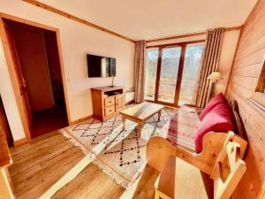 Appartement 3 pièces avec piscine et parking au centre du village - FR-1-505-198 في نوتر دام دو بيلكومبيه: غرفة معيشة بها أريكة وطاولة