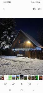 a barn with lights on it in the snow at Chalúpka Sokolí dvor in Terchová
