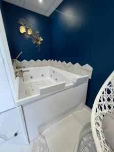 uma casa de banho com uma banheira branca numa parede azul em Appartement : Le Portel em Le Portel
