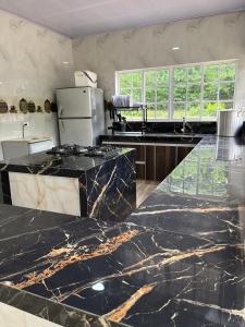 a kitchen with black marble counter tops and a refrigerator at Finca Nirvana. in Agua de Dios