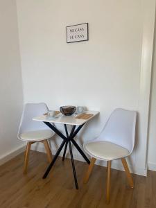 due sedie e un tavolo con una ciotola sopra di Gemütliche und charmante Ferienwohnung in der schönen Rattenfängerstadt Hameln a Hameln