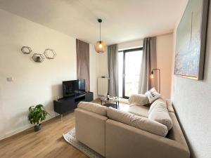 ein Wohnzimmer mit einem Sofa und einem TV in der Unterkunft Gemütliche und charmante Ferienwohnung in der schönen Rattenfängerstadt Hameln in Hameln