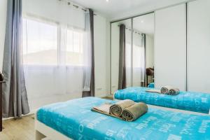 Dos camas en una habitación con espejo. en Santana Beach House, en Ribeira Grande