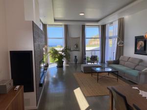 una sala de estar con un sofá y una mesa en Santana Beach House, en Ribeira Grande