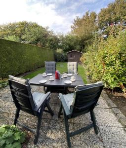 une table et deux chaises assises sur un patio en gravier dans l'établissement Spaanse Galeien 79 Cadzand, à Cadzand