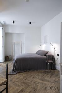a white bedroom with a bed and a wooden floor at Elegante Apartamento para 4 pax cerca de la Plaza de España in Seville