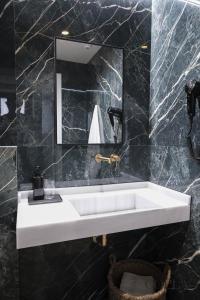 W łazience znajduje się biała umywalka i lustro. w obiekcie Elegante Apartamento para 4 pax cerca de la Plaza de España w Sewilli