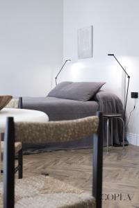 een slaapkamer met een bed en een witte muur bij Elegante Apartamento para 4 pax cerca de la Plaza de España in Sevilla