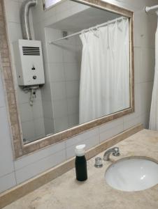 a bathroom with a sink and a mirror and a shower at Houselyon in Mendoza