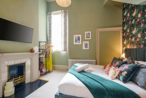 布里斯托的住宿－The Sovereign Suite - 2 Bedroom Apartment in Central Bristol by Mint Stays，一间卧室配有一张带壁炉和平面电视的床。