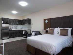a bedroom with a large bed and a kitchen at Hotel Montreal Metropolitan, BW Signature Collection in Montréal