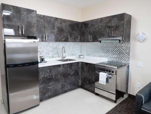 a kitchen with a stainless steel refrigerator and a sink at Hotel Montreal Metropolitan, BW Signature Collection in Montréal