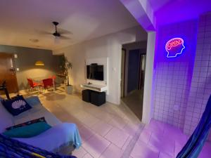 a living room with a purple light on the wall at Ap Temporada Enseada Azul in Guarapari