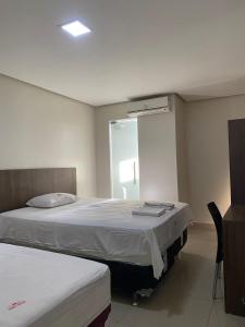 a bedroom with two beds and a mirror at Seller Hotel in Sobral